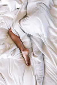 Woman Sleeping Under Sheets